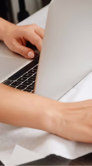 A person sitting in front of their laptop typing